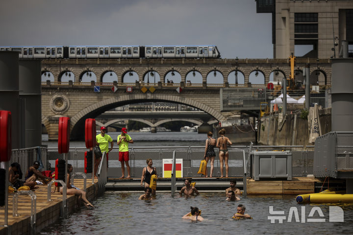 <font style="vertical-align: inherit;"><font style="vertical-align: inherit;">[파리=AP/뉴시스] 5일(현지 시간) 프랑스 파리 센 강 베르시에서 시민들이 수영을 하고 있다. 센 강은 100여 년 만에 공공 수영 공간으로 개방됐다. 마리 수로, 베르시 강변, 그르넬 항구 근처 등 세 곳이 야외 수영 구역으로 지정됐으며 오는 8월 31일까지 무료로 개방된다. 탈의실, 샤워 시설, 파라솔, 비치체어 등이 갖춰졌다. 2025.07.07.</font></font>