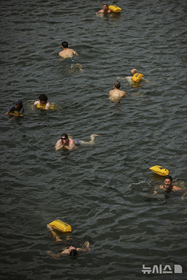 [파리=AP/뉴시스] 5일(현지 시간) 프랑스 파리 센 강에서 시민들이 수영을 하고 있다. 센 강은 100여 년 만에 공공 수영 공간으로 개방됐다. 마리 수로, 베르시 강변, 그르넬 항구 근처 등 세 곳이 야외 수영 구역으로 지정됐으며 오는 8월 31일까지 무료로 개방된다. 탈의실, 샤워 시설, 파라솔, 비치체어 등이 갖춰졌다. 2025.07.07.