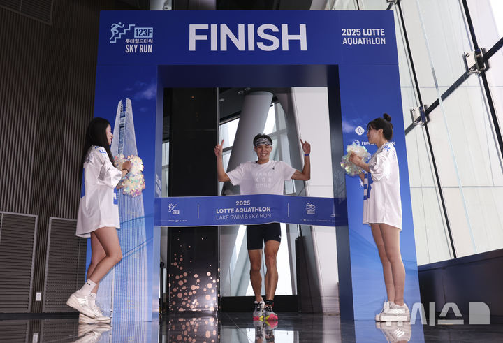 [서울=뉴시스] 김근수 기자 = 6일 오전 서울 송파구 롯데월드타워 일대에서 열린 '2025 롯데 아쿠아슬론'에서 참가자가 결승점을 통과하고 있다.   철인 3종 경기에서 사이클론을 제외한 오픈워터 수영과 마라톤을 함께 겨루는 '2025 롯데 아쿠아슬론'은 석촌호수 두 바퀴(총 1.5Km)를 완영 후, 롯데월드타워 1층부터 123층까지 2,917개의 계단을 오르는 수직 마라톤 스카이런(SKY RUN)으로 진행됐다. 2025.07.06. ks@newsis.com