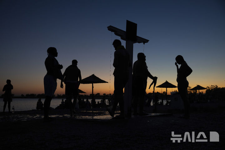 [글리파다(그리스)=AP/뉴시스]그리스 수도 아테네 남쪽 글리파다의 기온이 7일 40도를 넘을 것으로 예보된 가운데 6일 오후 더위를 견디지 못한 시민들이 야외에 설치된 샤워 시설에서 물줄기를 맞으며 더위를 식히고 있다. 그리스 당국은 7일 기온이 40도를 넘을 것으로 예상되는 일부 지역에 의무적 업무 휴식을 명령했다. 그리스의 폭염은 10일까지 이어질 것으로 예보됐다. 2025.07.07.