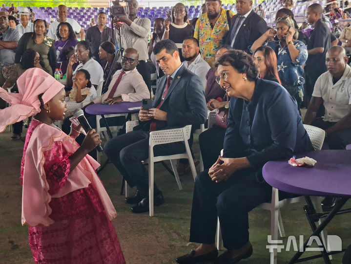 [파라마리보=AP/뉴시스] 6일(현지 시간) 수리남 역사상 첫 여성 대통령으로 선출된 제니퍼 헤얼링스 시몬스 국민민주당 대표가 파라마리보에서 열린 한 파티에서 어린이 노래 공연을 관람하고 있다. 2025.07.07.