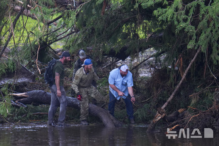 [헌트=AP/뉴시스] 6일(현지 시간) 미 텍사스주 헌트에서 자원봉사자들이 급류성 홍수가 휩쓸고 간 과달루페 강변의 기독교 청소년 캠프 '미스틱 야영장' 일대를 수색하고 있다. 텍사스주를 강타한 폭우와 홍수로 지금까지 사망자는 최소 80명, 실종자는 41명으로 늘어났다. 2025.07.07.