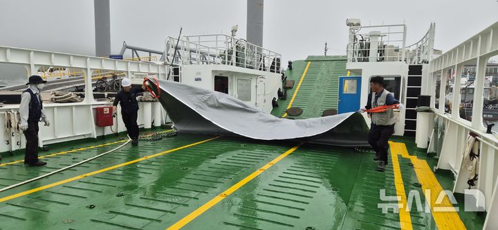 [서울=뉴시스] 안흥외항 여객선 '해랑5호' 차량 갑판에서 전기차 화재를 대비해 질식소화포 점검을 시행하는 모습.