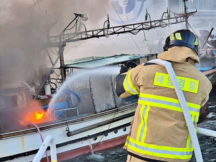 [거제=뉴시스] 신정철 기자= 7일 오전 5시 29분께 경남 거제시 장승포항 내에 계류중이던 부산선적 6t급 어선 A호(승선원 3명)에서 화재가 발생했다.사진은 통영해경 구조대원들이 진화작업을 펼치고 있다.(사진=통영해경 제공).2025.07.07. photo@newsis.com *재판매 및 DB 금지