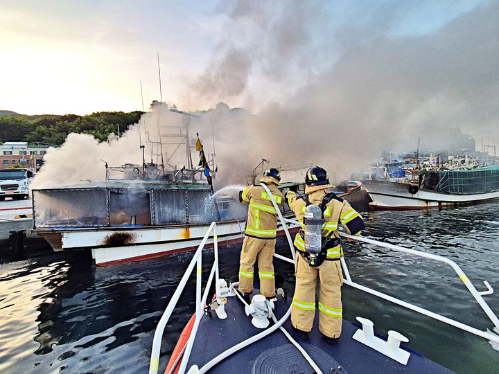 [거제=뉴시스] 신정철 기자= 7일 오전 5시 29분께 경남 거제시 장승포항 내에 계류중이던 부산선적 6t급 어선 A호(승선원 3명)에서 화재가 발생했다.사진은 통영해경 구조대원들이 진화작업을 펼치고 있다.(사진=통영해경 제공).2025.07.07. photo@newsis.com *재판매 및 DB 금지