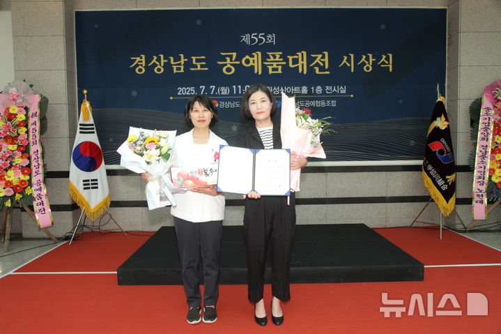 [창원=뉴시스]7일 오전 경남 창원 성산아트홀 전시관에서 제55회 경상남도 공예품대전 도자 분야에 '봄날의 햇살처럼 눈부신 날에'를 출품해 영예의 대상을 차지한 김해 문경유(오른쪽) 작가가 진필녀 경남도 문화산업과장으로부터 도지사 상장을 받은 후 기념촬영하고 있다.(사진=경남도 제공) 2025.07.07. photo@newsis.com