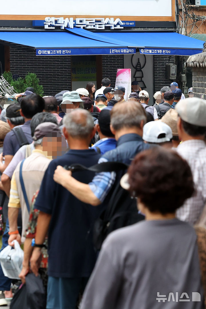 [서울=뉴시스] 최진석 기자 = 서울 전역에 올여름 첫 폭염경보가 내려진 7일 서울 탑골공원 인근에서 어르신들이 무료급식을 위해 줄지어 대기하고 있다. 2025.07.07. myjs@newsis.com