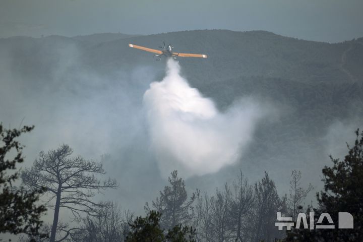[라타키아=AP/뉴시스] 7월 7일 시리아 라타키아 교외 라비아 인근 산불 현장에서 튀르키예 항공기 한 대가 물을 뿌리고 있다. 2025.07.11.