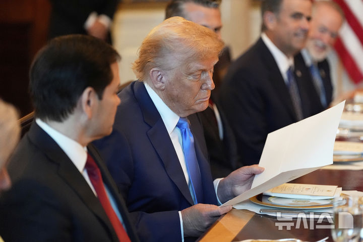 [워싱턴=AP/뉴시스] 도널드 트럼프 미국 대통령이 7일(현지 시간) 워싱턴DC 백악관에서 베냐민 네타냐후 이스라엘 총리와의 만찬에서 네타냐후 총리가 전달한 서류를 보고 있다. 네타냐후 총리는 이 자리에서 트럼프 대통령을 노벨평화성 후보로 추천했다고 밝혔으며 노벨위원회에 보낸 추천 서한을 트럼프 대통령에게 전달했다. 2025.07.08.