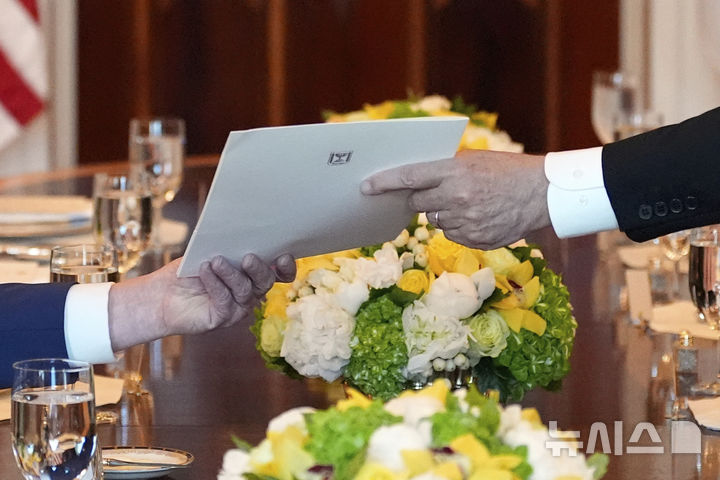 [워싱턴=AP/뉴시스] 베냐민 네타냐후 이스라엘 총리가 7일(현지 시간) 워싱턴 DC 백악관에서 도널드 트럼프 미국 대통령에게 서류를 전달하고 있다. 네타냐후 총리는 이 자리에서 트럼프 대통령을 노벨평화성 후보로 추천했다고 밝혔으며 노벨위원회에 보낸 추천 서한을 트럼프 대통령에게 전달했다. 2025.07.08.