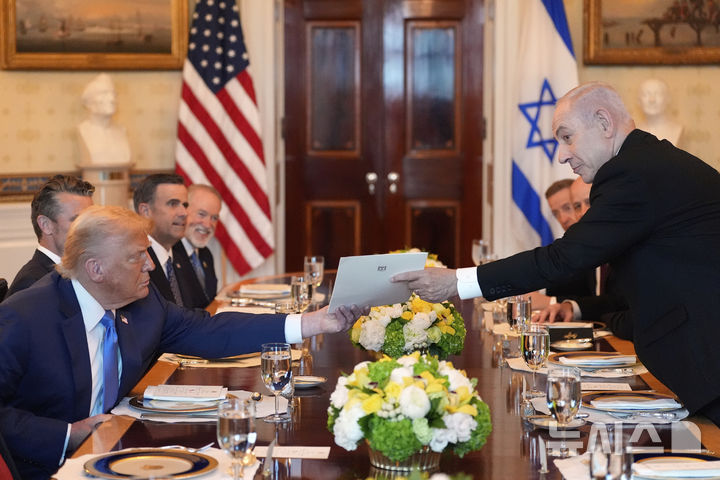 [워싱턴=AP/뉴시스] 베냐민 네타냐후 이스라엘 총리(오른쪽)가 지난 7일(현지 시간) 백악관 블루룸에서 열린 미-이스라엘 당국자 만찬에 앞서 도널드 트럼프 미국 대통령에게 서류철을 건네고 있다. 2025.07.10.