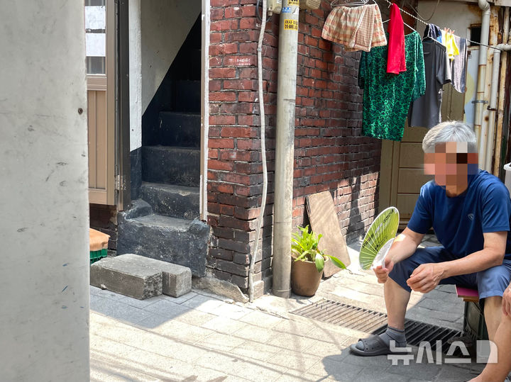 [서울=뉴시스]이채은 인턴기자 = 8일 폭염 경보가 발효 중인 서울 영등포구 쪽방촌에서 한 주민이 집안 내부의 찜통더위를 피해 골목에 나와 앉아있다. 2025.07.08