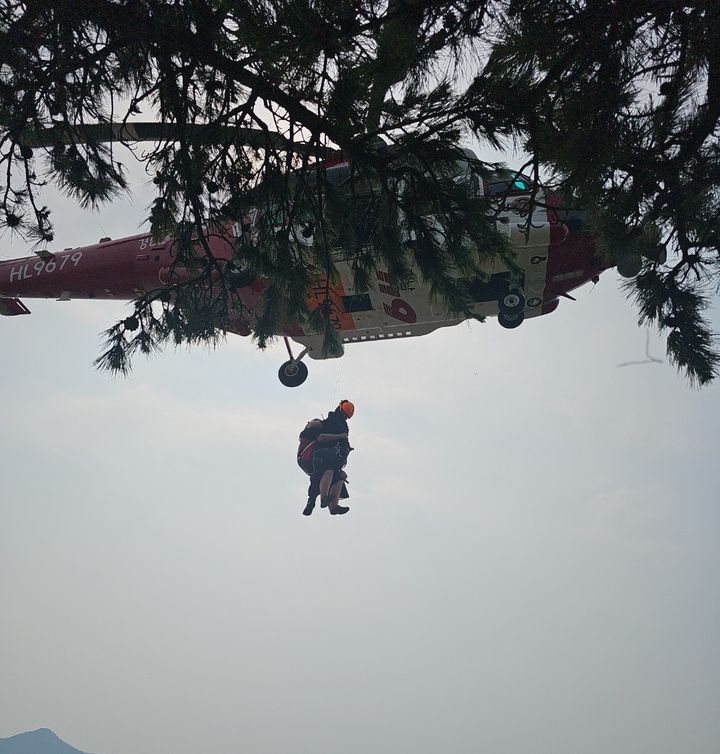 [군산=뉴시스] 8일 오후 1시39분께 전북 군산시 옥도면 대장도리 내 대장봉을 등산하던 A(50대·여)씨가 어지럼증을 호소해 소방대원에 의해 헬기로 이송되고 있다. (사진=전북도소방본부 제공) 2025.07.08.. photo@newsis.com *재판매 및 DB 금지
