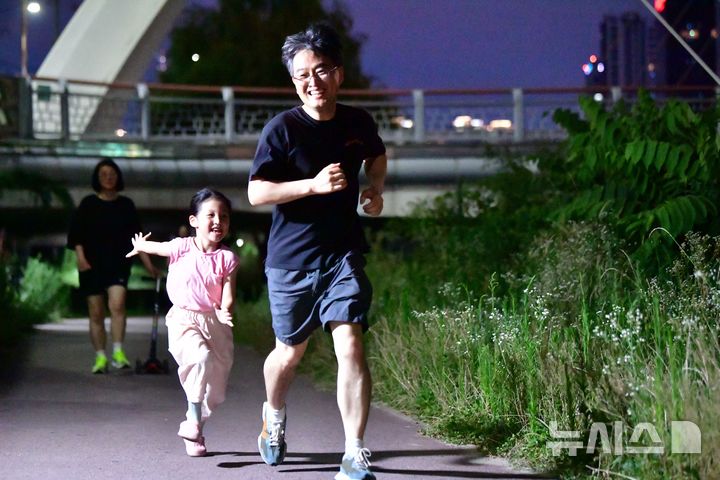 [광주=뉴시스] 이현행 기자= 8일 오후 광주 동구 광주천변 인근에서 더위를 피해 산책나온 아빠와 아이가 잡기놀이를 하고 있다. 2025.07.08 lhh@newsis.com