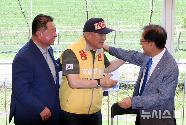 [파주=뉴시스] 조성우 기자 = 최성룡(가운데) 납북자피해가족연합회 대표가 8일 경기 파주시 임진각 한반도생태평화 종합관광센터에서 기자회견을 열고 대북 전단 살포 중단을 선언한 뒤 윤후덕(오른쪽) 의원과 김경일 파주시장과 함께 포옹하고 있다. 2025.07.08. xconfind@newsis.com