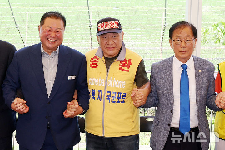 [파주=뉴시스] 조성우 기자 = 최성룡(가운데) 납북자피해가족연합회 대표가 8일 경기 파주시 임진각 한반도생태평화 종합관광센터에서 기자회견을 열고 대북 전단 살포 중단을 선언한 뒤 윤후덕(오른쪽) 의원과 김경일 파주시장과 손을 잡고 기념촬영하고 있다. 2025.07.08. xconfind@newsis.com