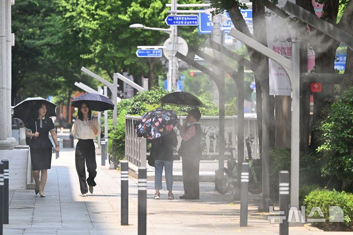 [광주=뉴시스] 이영주 기자 = 광주지역에 폭염특보가 이어진 지난 8일 오후 광주 동구 금남로에서 시민들이 양산을 쓴 채 쿨링포그 주변을 걷고 있다. 2025.07.08. leeyj2578@newsis.com