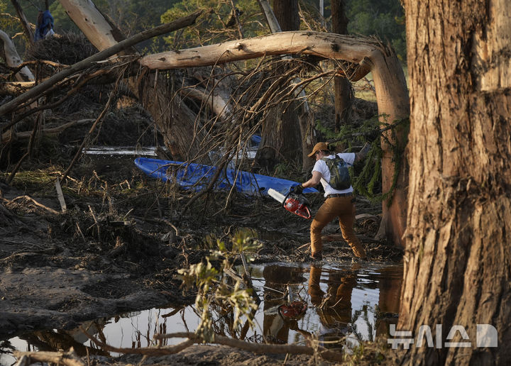 <font style="vertical-align: inherit;"><font style="vertical-align: inherit;">[텍사스=AP/뉴시스] 8일(현지 시간) 미국 텍사스주 잉그램 과달루페 강 인근 홍수 피해 현장에서 자원봉사자가 실종자 수색 및 복구 작업을 하고 있다. 2025.07.09.</font></font>