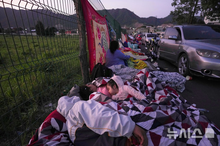 <font style="vertical-align: inherit;"><font style="vertical-align: inherit;">[팔린=AP/뉴시스] 과테말라에서 규모 5.7의 지진이 발생한 가운데 9일(현지 시간) 팔린에서 야외로 피신한 주민들 모습. 현지 당국은 지난 8일 오후부터 규모 3.0에서 5.7의 본진과 여진이 150차례 이상 이어지며 최소 4명이 숨졌다고 밝혔다. 2025.07.10.</font></font>