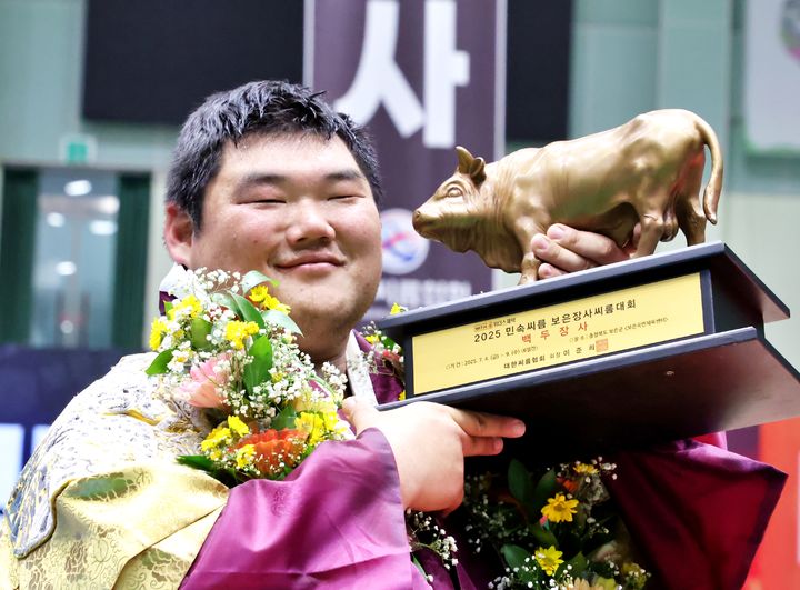 [서울=뉴시스] 9일 충청북도 보은군 보은국민체육센터에서 열린 ‘위더스제약 2025 민속씨름보은장사씨름대회’ 백두장사에 등극한 김동현(용인특례시청)이 황소트로피를 들고 기념사진을 찍고 있다. (사진=대한씨름협회 제공) *재판매 및 DB 금지