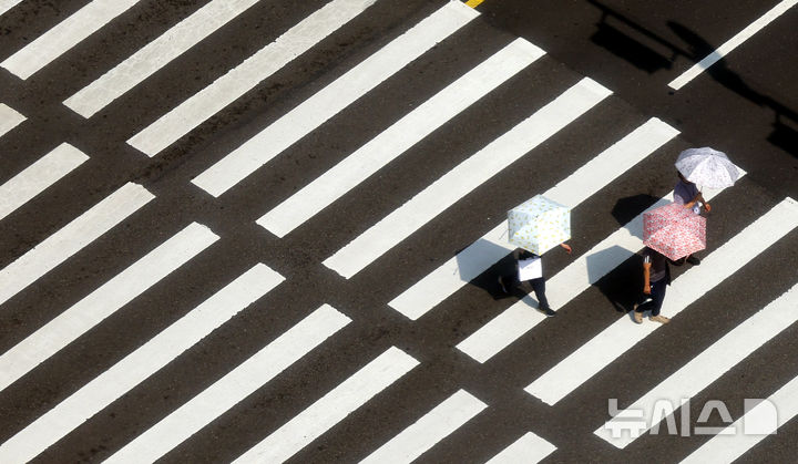 [서울=뉴시스] 박주성 기자 = 7월 초 이례적인 폭염으로 경기도 광명, 파주 등 일부 지역에서 낮 기온이 40도를 넘어선 가운데 9일 서울시청앞 횡단보도에 시민들이 양산을 쓰고 이동하고 있다. 2025.07.09. park7691@newsis.com