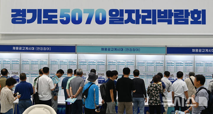 [수원=뉴시스] 김종택 기자 = 지난 9일 경기 수원시 권선구 수원메쎄에서 열린 '경기도 5070 일자리 박람회'에서 중장년 구직자들이 채용공고게시대를 살펴보고 있다. 2025.07.09. jtk@newsis.com