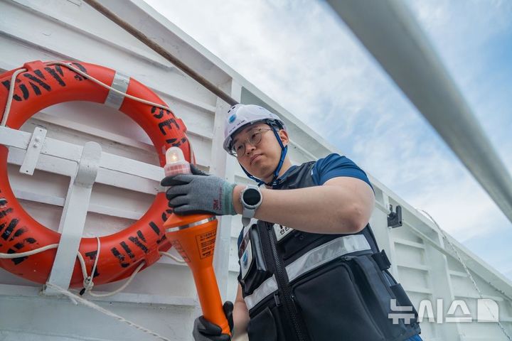 [서울=뉴시스] 한국해양교통안전공단(KOMSA) 운항관리자가 '구명부환'과 '자기점화등' 등 연안여객선의 구명설비와 조난신호장비를 점검하고 있다.