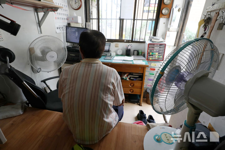 [서울=뉴시스] 조성우 기자 = 전국에 폭염특보가 내려진 14일 오후 서울 시내 한 아파트 경비실에서 경비원이 선풍기를 이용해 더위를 식히고 있다. 2021.07.14. xconfind@newsis.com