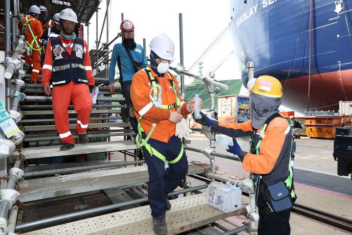 [거제=뉴시스] 신정철 기자= 한화오션(대표이사 김희철 사장)이 10일, 예년보다 일찍 극성을 부리기 시작한 폭염을 극복하기 위해 다양한 온열질환 예방 활동을 전개하며 직원들의 건강을 살피고 있다.사진은 폭염에 가장 취약한 작업장인 안벽 작업장 등 실외 작업이 빈번한 곳을 직접 찾아가, 얼음생수를 제공하고 있는 모습.(사진=한화오션 제공).2025.07.10. photo@newsis.com *재판매 및 DB 금지