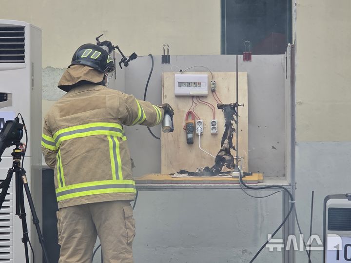 [부산=뉴시스] 김민지 기자 = 10일 오후 부산 연제구 부산소방재난본부 훈련탑 앞에서 진행된 멀티탭 발화 실험에서 불이 난 멀티탭을 소방관이 진화하고 있다. 2025.07.10. mingya@newsis.com