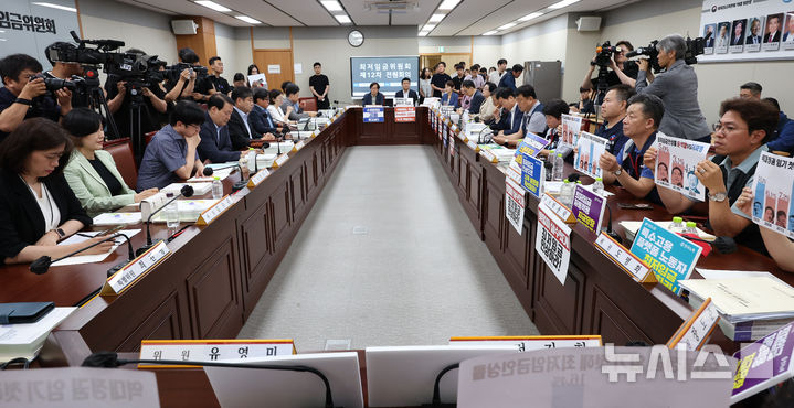 [세종=뉴시스] 강종민 기자 = 10일 세종시 정부세종청사에서 열린 최저임금위원회 제12회 전원회의에서 근로자 위원이 윤석열 정부와 이재명 정부의 최저임금인상율이 적인 피켓을 들어보이고 있다. 2024.07.10. ppkjm@newsis.com