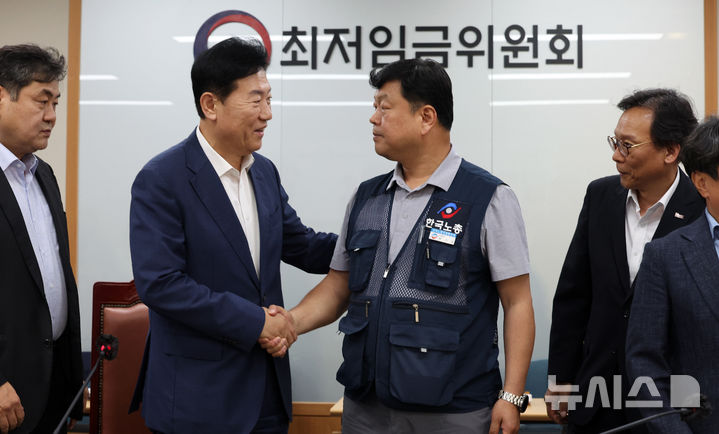[세종=뉴시스] 강종민 기자 = 10일 밤 세종시 정부세종청사에서 열린 최저임금위원회 전원회의에서 2026년도 적용 최저임금이 1만 320원으로 결정됐다. 회의가 끝난 후 류기정 사용자 위원과 류기섭 근로자 위원이 악수하고 있다. 이날 민주노총은 공익위원이 제시한 심의촉진구간에 반발, 집단 퇴장했다. 2024.07.10. ppkjm@newsis.com