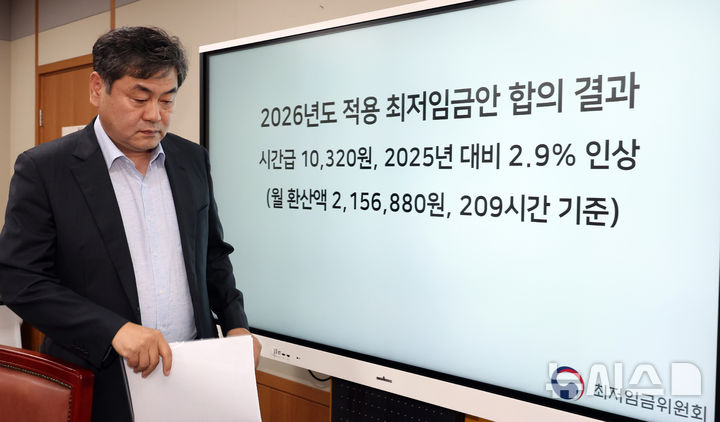 [세종=뉴시스] 강종민 기자 = 이인재 최저임금위원장이 지난해 7월 10일 밤 세종시 정부세종청사에서 열린 최저임금위원회 제12차 전원회의를 마친 뒤 2026년도 적용 최저임금안 합의 결과 앞을 지나고 있다. 2024.07.10. ppkjm@newsis.com