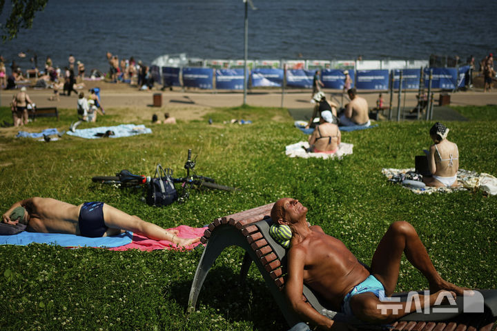 <font style="vertical-align: inherit;"><font style="vertical-align: inherit;">[모스크바=AP/뉴시스] 더운 날씨를 보인 10일(현지 시간) 러시아 모스크바의 모스크바 운하 인근에서 시민들이 일광욕을 하고 있다. 2025.07.11.</font></font>