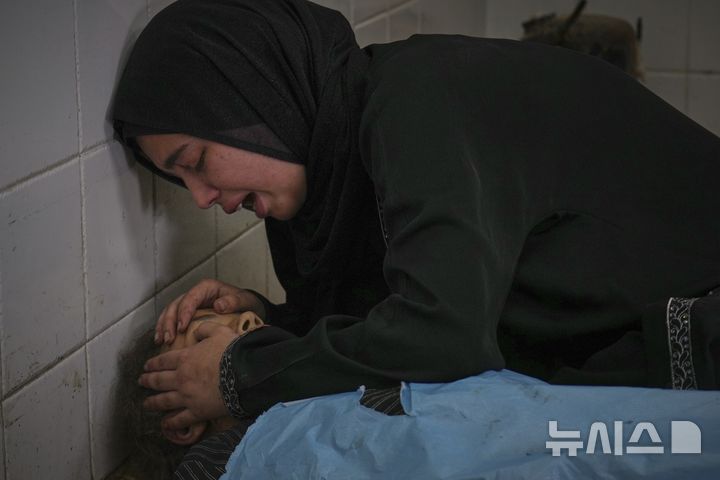 [가자지구=AP/뉴시스] 가자지구 데이르 알발라에 있는 '프로젝트 호프' 운영 의료 클리닉 앞에서 영양 보충제를 기다리다 이스라엘의 공습으로 숨진 13세 여동생 사마의 시신을 붙잡고 오열하고 있다. 