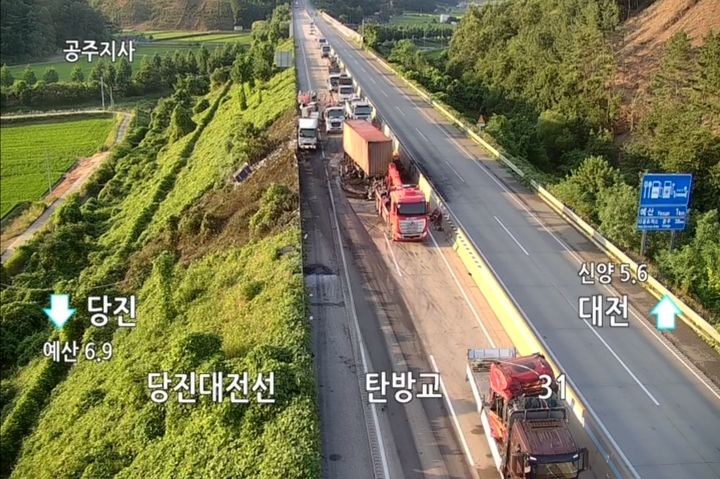 [예산=뉴시스] 11일 오전 3시45분께 당진영덕고속도로 당진방향 31㎞ 지점 충남 예산군 대흥면에서 3중 추돌사고 후 불이 나 현장에 출동한 경찰과 소방대원들이 현장을 수습하고 있다. (사진-한국도로공사 CCTV 화면 갈무리) 2025.07.11. photo@newsis.com *재판매 및 DB 금지
