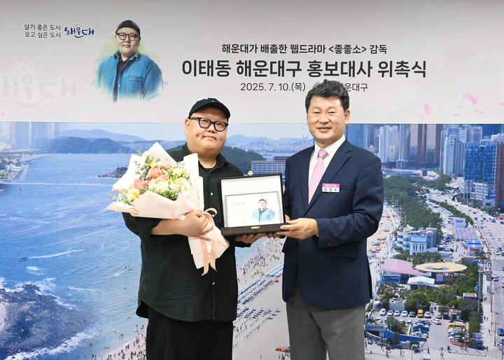 [부산=뉴시스] 10일 해운대구 홍보대사로 위촉된 이태동(왼쪽) 감독과 김성수 구청장이 사진 촬영을 하고 있다. (사진=부산 해운대구 제공) 2025.07.11. photo@newsis.com *재판매 및 DB 금지