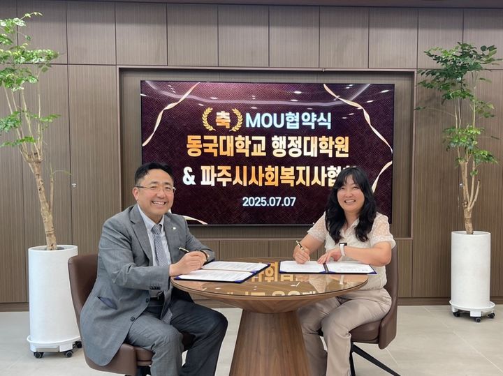 동국대 행정대학원 황재현 원장(왼쪽)과 파주시사회복지사협회 김미연 회장이 협약서에 서명하고 있다. (사진=동국대 제공) *재판매 및 DB 금지