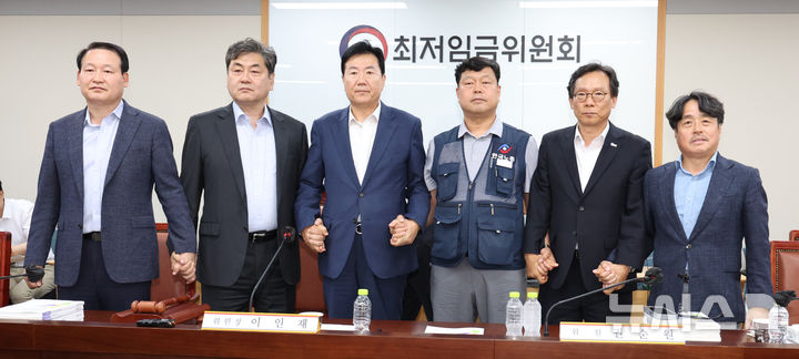 [세종=뉴시스] 강종민 기자 = 최저임금위원회 이인재 위원장과 권순원 공익위원, 류기정 사용자 위원, 류기섭 근로자 위원 등이 지난 10일 밤 세종시 정부세종청사에서 2026년도 적용 최저임금안을 합의로 결정한 뒤 손을 맞잡고 있다. 2024.07.11. ppkjm@newsis.com