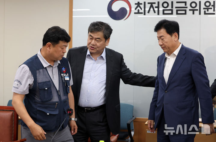 [세종=뉴시스] 강종민 기자 = 최저임금위원회 이인재 위원장이 지난 10일 밤 세종시 정부세종청사에서 2026년도 적용 최저임금안을 합의로 결정한 뒤 류기정 사용자 위원과 류기섭 근로자 위원을 불러 모으고 있다. 내년도 최저임금은 1만 320원으로 결정됐다. 2024.07.11. ppkjm@newsis.com