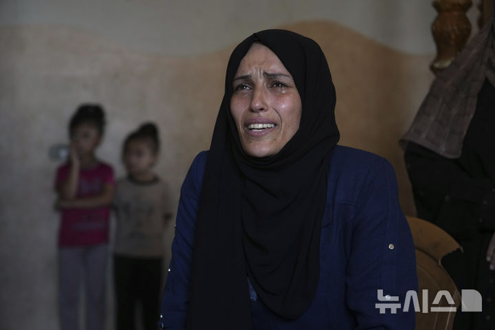 [데이르알발라=AP/뉴시스] 가자지구 데이르 알발라에 위치한 자택에서 인터뷰 도중 감정을 드러내는 이만 알누리. 그녀는 배급을 받기 위해 기다리던 중 이스라엘의 공습으로 두 자녀를 잃었다. 2025.07.12.