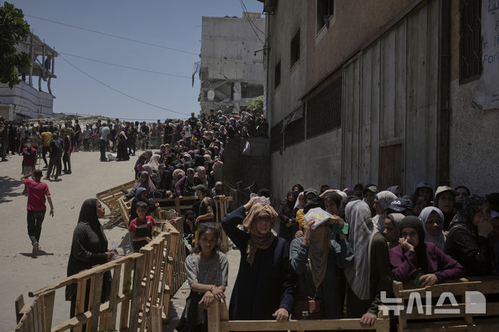 [AP/뉴시스] 4개월 만 처음으로 가자 지구 북부의 가자 시티에서 12일 유엔 세계식량프로그램(WFP)의 밀가루 배급에 주민들이 줄 서 기다리고 있다