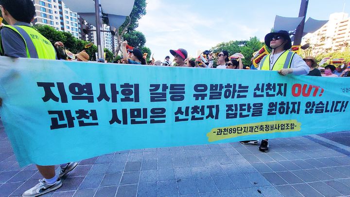 [과천=뉴시스] 박종대 기자 = 12일 오후 경기 과천중앙공원에서 열린 '신천지 예배시설 용도변경 반대 집회'에 참가한 시민들이 '신천지 집단을 원하지 않습니다'라고 적힌 현수막을 들고 행진하고 있다. 집회 참가자들은 신천지의 대형마트 건물 종교시설 용도변경 추진에 반대하며 약 750m 구간을 행진했다. 2025.07.12. pjd@newsis.com *재판매 및 DB 금지
