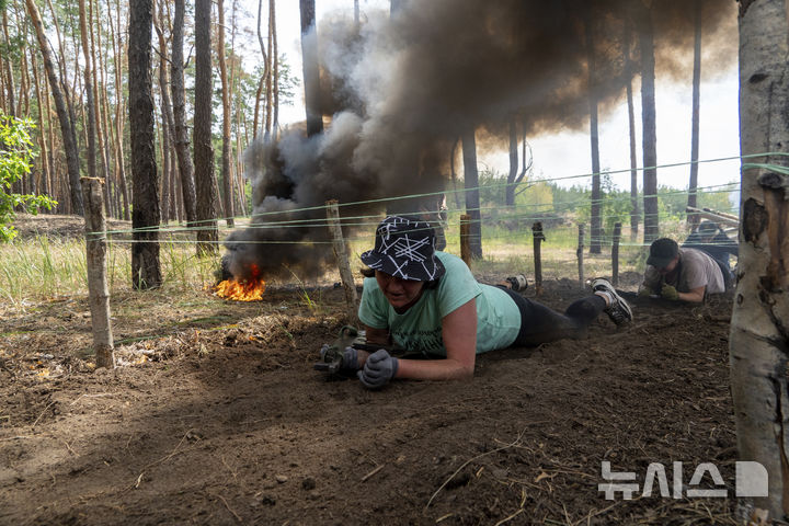 [AP/뉴시스] 우크라이나 동북부 하르키우주 훈련장에서 12일 시민들이 군사 기술을 익히고 있다 