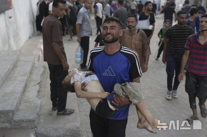  [시파=AP/뉴시스] 12일(현지 시간) 가자지구 시파 병원에서 팔레스타인인이 이스라엘군의 공습으로 사망한 자녀의 시신을 옮기고 있다. 2025.07.14. 