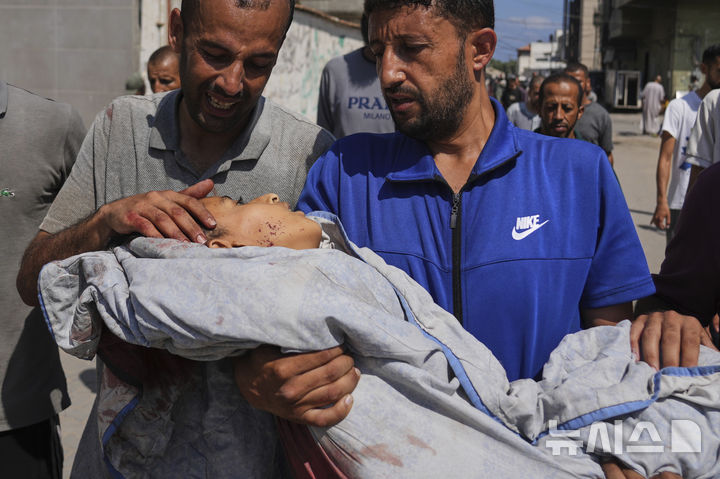 [AP/뉴시스] 13일 가자 북부 누제이랏 난민캠프의 식수 배급차 앞에서 줄서있다 공습에 사망한 13살 아들 시신을 묻기 위해 알아우다 병원 밖에서 아버지가 안고 있다 