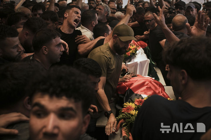  [알마즈라=AP/뉴시스] 13일(현지 시간) 가자지구 알마즈라 아샤르키야 마을에서 열린 팔레스타인계 미국인의 장례식에서 조문객들이 시신을 옮기고 있다. 팔레스타인 보건부에 따르면, 무살레트는 이스라엘의 공격으로 사망했다. 2025.07.14. 