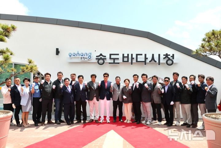 [포항=뉴시스] 송종욱 기자 = 경북 포항시가 지난 12일 18년 만에 송도해수욕장 재개장과 바다시청 준공식을 개최했다. 사진은 송도바다시청 준공식에서 이강덕 시장과 김일만 시의장, 김정재·이상휘 국회의원, 시도의원, 기관 단체장이 송도바다시청 이름을 덮은 천을 걷어내는 제막식을 갖고 파이팅을 외치며 기념 촬영하는 모습. (사진=포항시 제공) 2025.07.13. photo@newsis.com