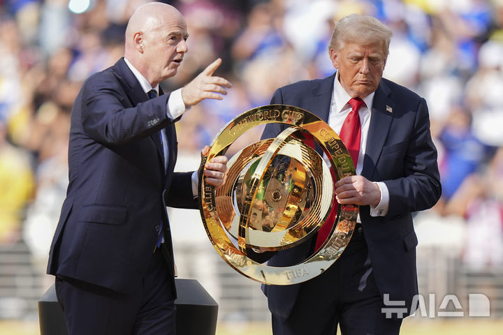 [이스트 러더퍼드=AP/뉴시스] 도널드 트럼프(오른쪽) 미국 대통령과 잔니 인판티노 국제축구연맹(FIFA) 회장이 13일(현지 시간) 뉴저지주 이스트 러더퍼드의 메트라이프 스타디움에서 열린 2025 FIFA 클럽 월드컵 첼시(잉글랜드)와 파리 생제르맹(PSG, 프랑스)의 결승전이 끝난 후 우승컵을 함께 들고 이동하고 있다. 첼시가 PSG를 3-0으로 완파하고 우승컵을 들어 올렸다. 2025.07.14.