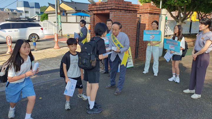 [고성(경남)=뉴시스] 신정철 기자= 경상남도고성교육지원청(교육장 전제동)은 14일 오전 8시 10분부터 고성초등학교 정문에서 유관기관과 합동으로 학생 물놀이 안전사고 예방 캠페인 활동을 전개했다.사진은 전제동 고성교육장이 안전한 물놀이를 할 수 있도록 안내하는 자료를 학생들에게 배부하고 있는 모습.(사진=고성교육지원청 제공).2025.07.14. photo@newsis.com *재판매 및 DB 금지